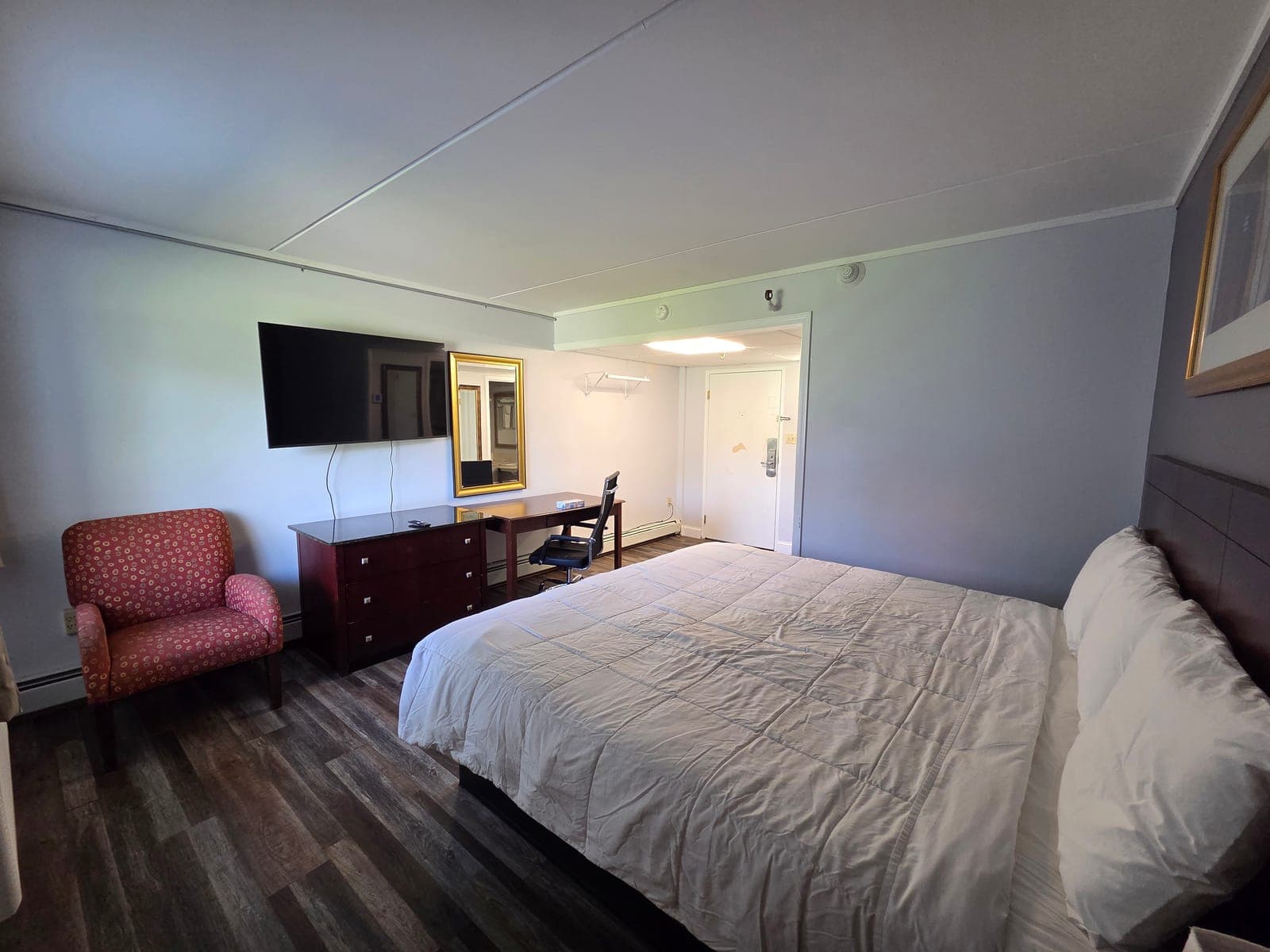 Saffron Inn king ground-floor room — alternate angle showing the bed, work desk, granite-top side table, and step-free access to the door