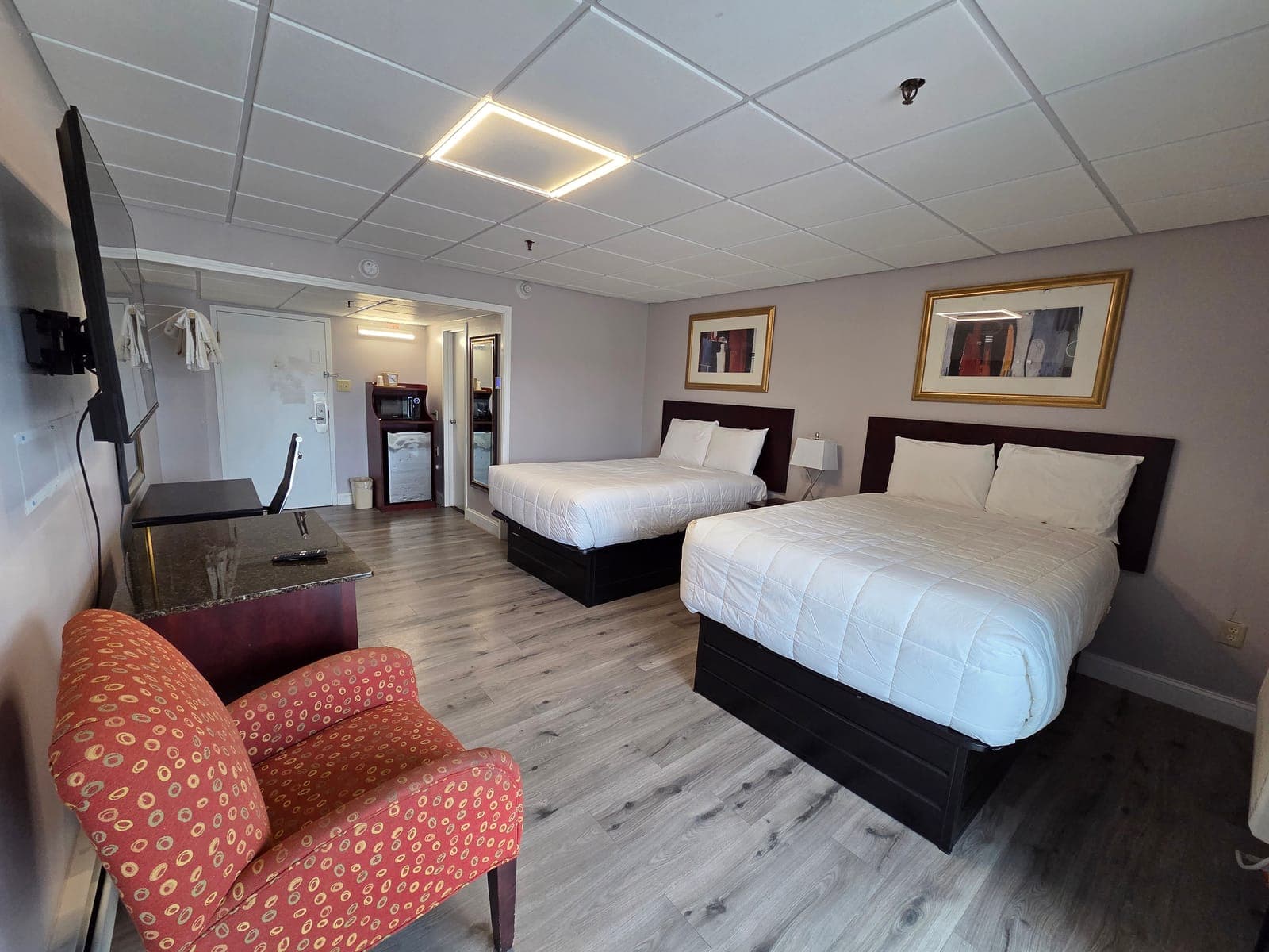 Saffron Inn two-double balcony room — alternate angle showing the second bed, work desk, and balcony door